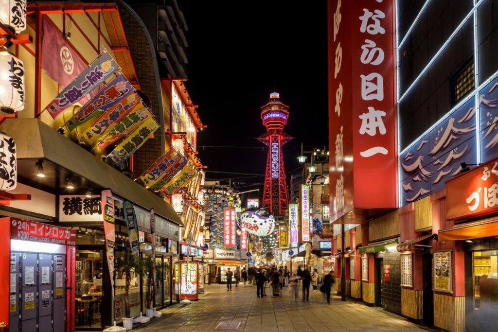 Colorful Shinsekai street with Tsutenkaku Tower rising above the neighborhood in Osaka