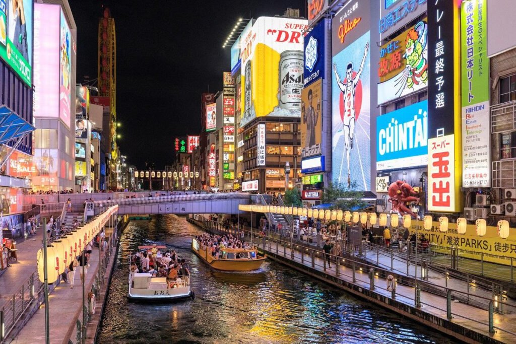 Dotonbori canal illuminated by colorful neon signs at night in Osaka, Japan