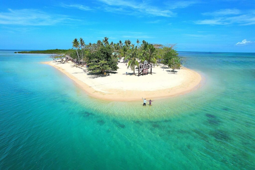 White sand beach and turquoise water at Cowrie Island in Honda Bay