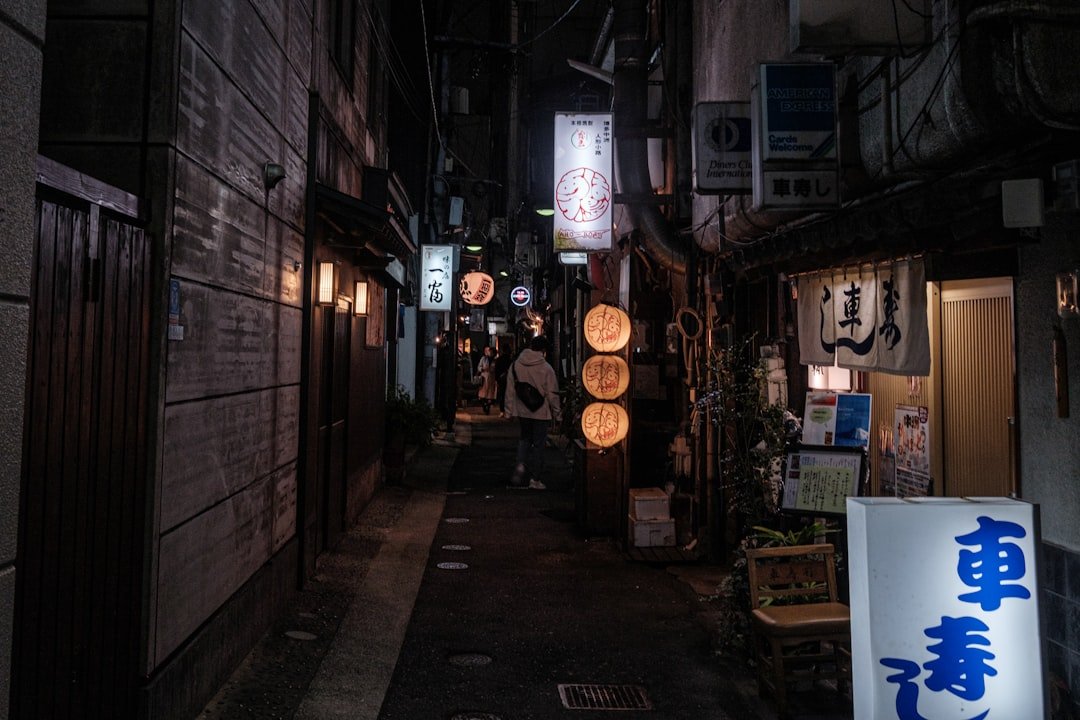 Narrow illuminated alley with shop signs in Hakata, Fukuoka