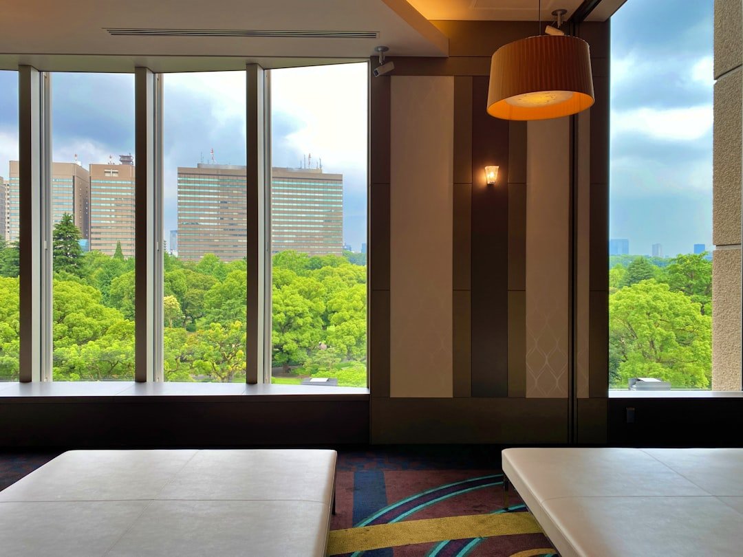 Illustrative Tokyo hotel room with large windows and a green city view